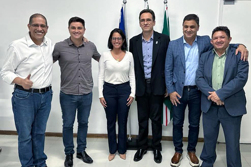 Seis pessoas abraçadas e sorrindo para a camera.